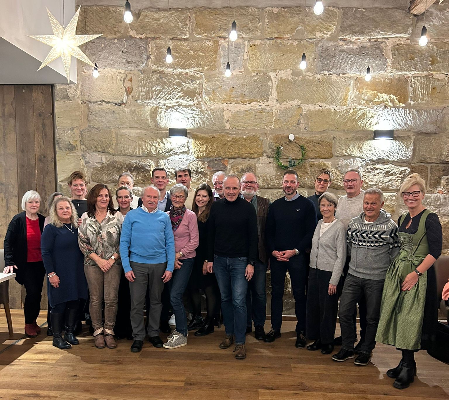 UBE Mitglieder stehen versammelt vor einer Steinmauer der Gaststätte. Jahresabschlussfeier am 14.12.2025