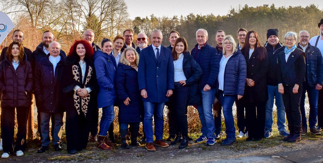 Die 24 Kandidatinnen und Kandidaten der UBE stehen in einer Reihe vor dem Schneiderweiher in Eckenhaid. Im Hintergrund sind der Weiher und Bäume zu sehen.
